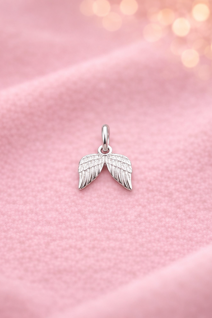 Silberner Anhänger Schutzflügel auf rosa Tuch