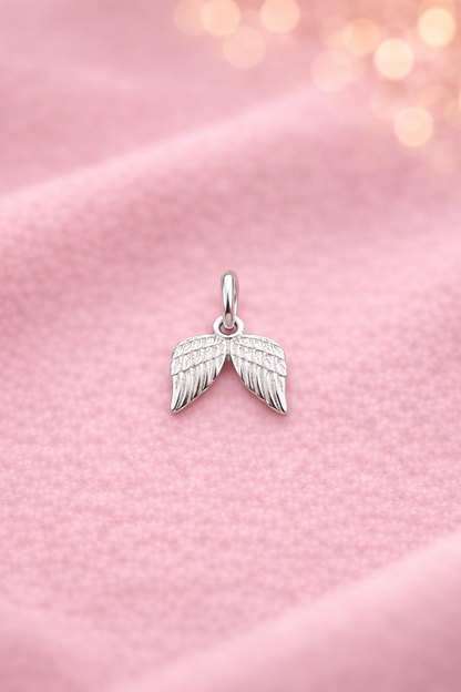 Silberner Anhänger Schutzflügel auf rosa Tuch