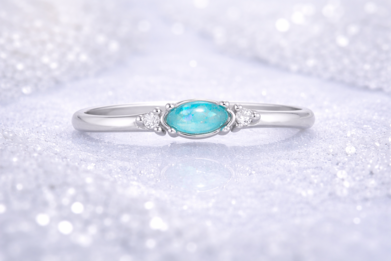 Ring Aqua mit blauem Zierstein auf gefrorenem Wasser