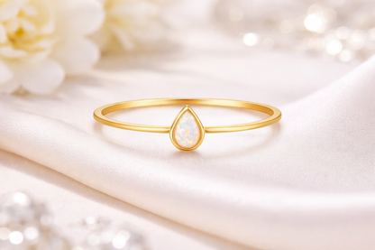 Ring Drop gold mit hellem Zierstein auf weissem Tuch