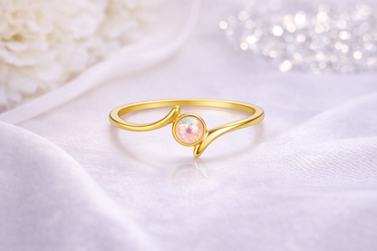Ring Essence gold mit heller Zierperle auf hellem Tuch